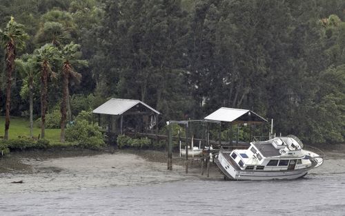 A boat rests on its side in what is normally six feet of water in Old Tampa Bay. (AP)