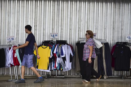 Residents walk past a storefront, paneled with steel sheets in preparation for Hurricane Irma, in Carolina, Puerto Rico. (AP)