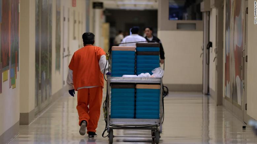 A detainee worker moves a cart of trays containing chicken fajita meals to be served to detainees during a media tour of the ICE detention centre in Tacoma, Washington, in 2019.