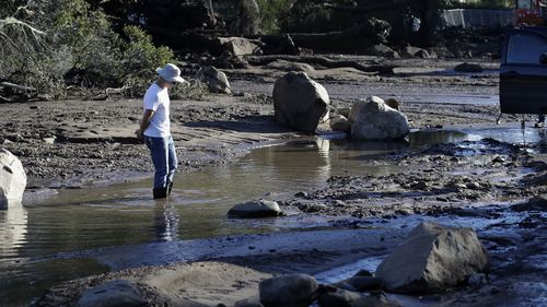 A man stands in flooded waters in Montecito on Wednesday. (AAP)