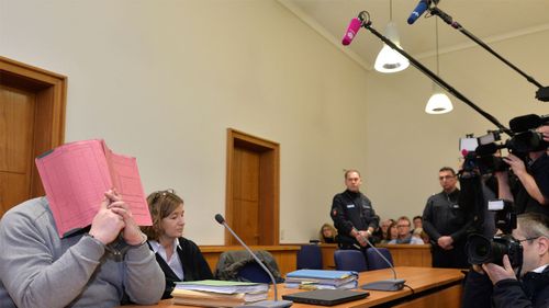 In this Feb. 26, 2015 file photo former nurse Niels Hoegel, accused of multiple murder and attempted murder of patients, covering his face with a file at the district court in Oldenburg, Germany. German authorities say Monday Aug. 28, 2017 they now believe that a nurse who was convicted of killing patients with overdoses of heart medication killed at least 84 people. Niels Hoegel was convicted in 2015 of two murders and two attempted murders at a clinic in the northwestern town of Delmenhorst. Oldenburg police chief Johann Kuehme said Monday authorities have now unearthed evidence of 84 killings. (Carmen Jaspersen/dpa via AP,file)