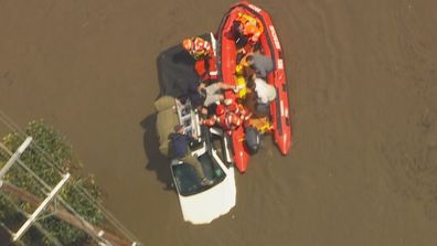 Le véhicule était plein à craquer d'effets personnels, y compris ce qui ressemble à un butin.  Les volontaires de SES ont utilisé toutes leurs forces pour stabiliser leur bateau à cause du torrent d'eau.