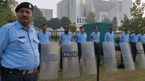 Pakistani police officers stand guard outside the supreme court in Islamabad during the hearing of Asia Bibi.