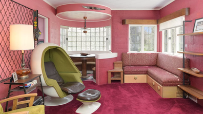 The plush pink carpet and walls of the home's study.