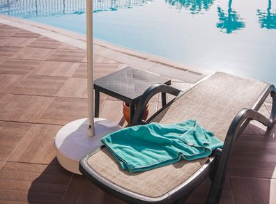 Sun-lounger and towel near the pool. Background for concept summer vacation