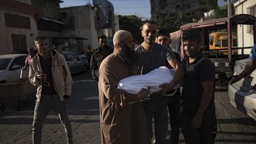 Palestinian carry a child killed in the Israeli bombardment