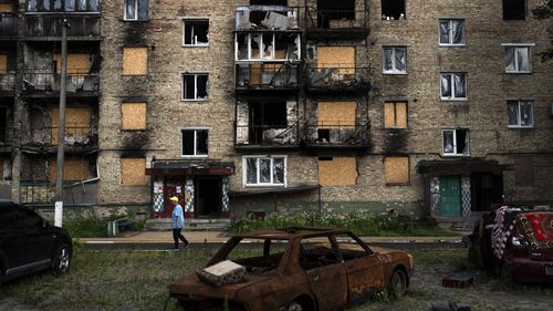 A resident walks past an apartment building heavily damaged in Russian attacks in Irpin, Ukraine.