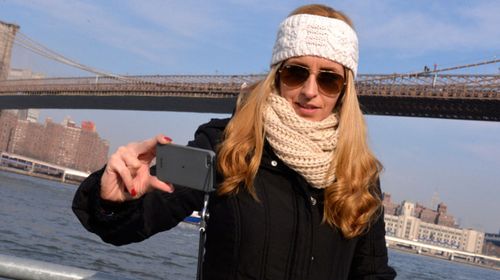 This unidentified woman's earned the title of "world's most selfish selfie" in December 2013 for snapping a photo in front of a suicidal man about to jump off New York's Brooklyn Bridge . (Paul Martinka)