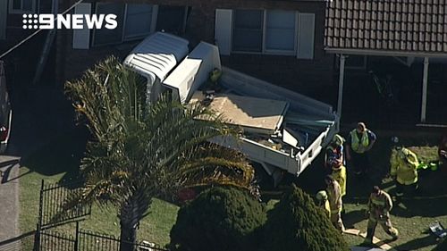 The truck hit a pedestrian before crashing into a house. (9NEWS)