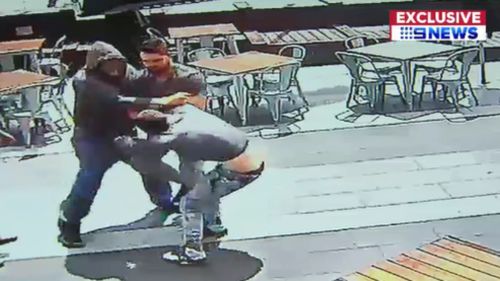 The taller, hooded man can be seen punching his victim. (9NEWS)