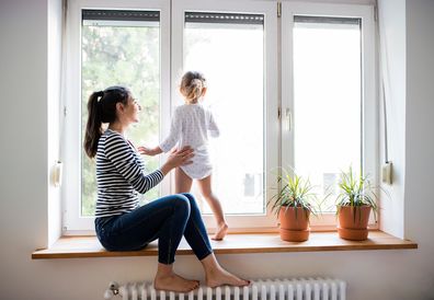 Mum and daughter playing on window sill.