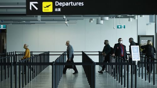 MELBOURNE, AUSTRALIA - NOVEMBER 23: People are seen at Melbourne Airport checking in for flights to New South Wales on November 23, 2020 in Melbourne, Australia. COVID-19 restrictions have relaxed further in Victoria as the state continues to record no new coronavirus cases. From Monday, Victorians no longer need to wear masks when outside at all times, with people only required to wear masks when indoors and on public transport, or in places outside where social distancing is not possible. Unde