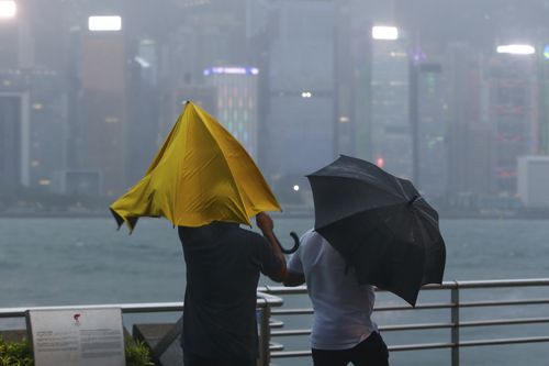 People with umbrellas struggle against the strong wind and rain brought by super typhoon Saola in Hong Kong, on Friday, Sept. 1, 2023.  