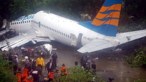 Rescuers try to find survivors from a commercial plane after it skidded off the runway at Manokwari airport in West Papua, Indonesia on April 2010. An Indonesian plane with over 100 people on board skidded off the runway injuring at least 20 people.