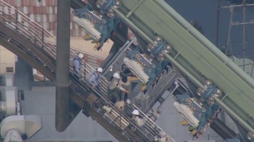 Sixty-four passengers were left hanging, about 30m from the ground. (NHK / AP)