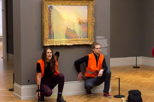 Climate activists kneel in front of the Monet painting.