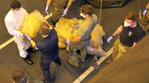 Sailors from HMS Dragon unload the drugs found on the dhow.