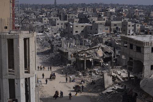 Des Palestiniens traversent les destructions consécutives à une offensive aérienne et terrestre israélienne à Khan Younis, dans le sud de la bande de Gaza, le lundi 8 avril 2024. 