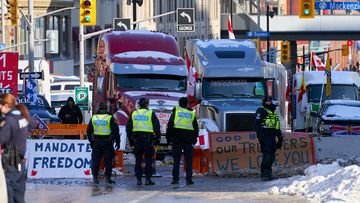 Policemen stand near the truckers sit-in, after the mayor of Ottawa has declared a state of emergency in the Canadian capital after a 10-day-long protest by truck drivers over Covid-19 restrictions that has gridlocked its city center, in Ottawa, Canada, 07 February 2022. 