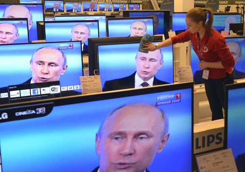 An employee wipes a TV screen in a shop in Moscow, during the broadcast of President Vladimir Putin's televised question and answer session with the nation. Source: AFP / ALEXANDER NEMENOV