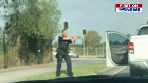 A police officer points his gun at the accused. Picture: 9NEWS