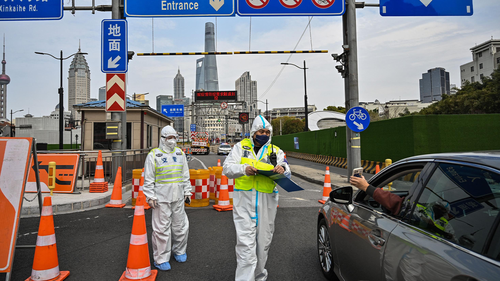 A police officer, centre, wearing protective gear, controls access to a tunnel in the direction of Pudong district in lockdown as a measure against the COVID-19 coronavirus, in Shanghai on March 28.