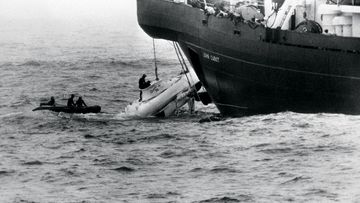 Divers begin to open the hatch of the minature submarine Pisces III as she breaks water under the John Cabot after being hauled from the Atlantic seabed off Cork. 