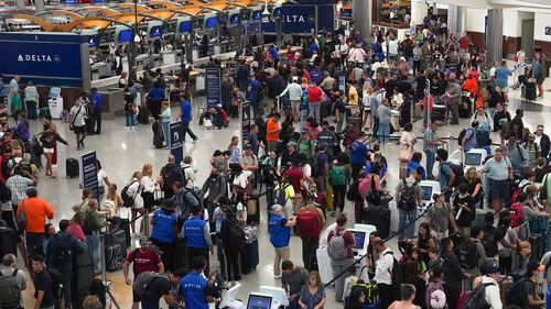 People wait in line at Hartsfield-Jackson International Airport on July 20 in Atlanta, Georgia.