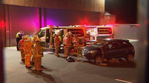 Paramedics treat the man who was trapped under the car. Picture: 9News