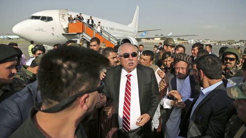 Afghan first vice president, a former Uzbek warlord, General Abdul Rashid Dostum, (centre), and members of his entourage arrive at Kabul International Airport in Kabul, Afghanistan. (AAP)