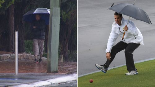 A Sydneysider (left), and cricket umpire Shawn Craig - at the Hurstville Oval - battle rain. (9NEWS, AAP)