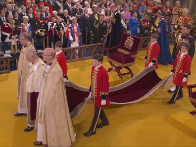 King Charles stands in Westminster Abbey during his coronation. Prince Harry can be seen in the background.