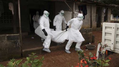 Liberian nurses carry the body of an Ebola victim from a house during an outbreak in 2015. Source: AAP.