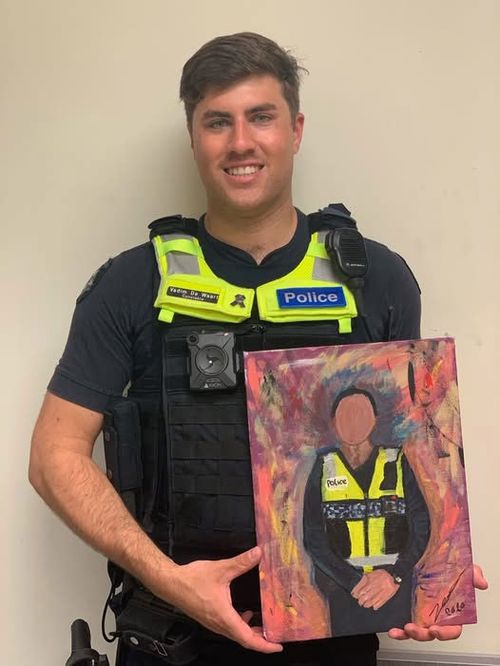 Senior Constable Vadim de Waart-Hottart, shown holding a portrait of himself, painted by an appreciative community member.