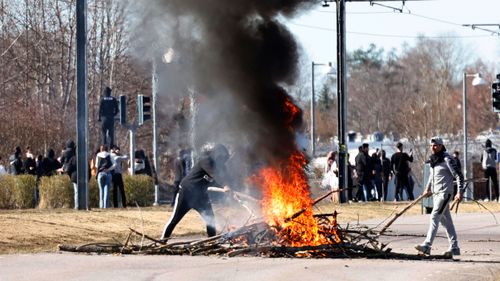 People burn branches to block a road during a riot in Norrkoping, Sweden.