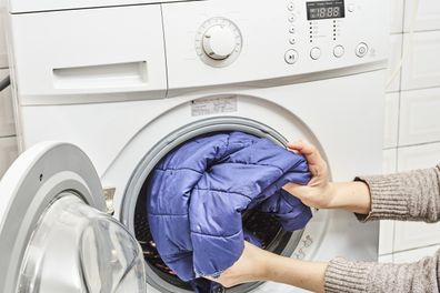 woman washing dirty laundry in the washing machine