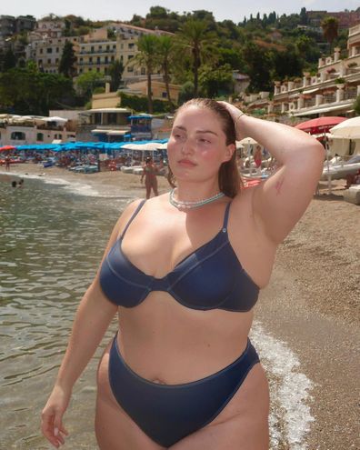 Riley Hemson poses on a beach in Europe.