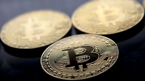 Moedas Bitcoin de souvenir banhadas a ouro são organizadas para uma fotografia em Londres em novembro de 2017. O Bitcoin atingiu um novo recorde acima de US$ 80.000 em 10 de novembro.