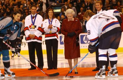 Canadian hockey great Wayne Gretzky (2nd from R), Vancouver Canucks, Ed Jovanovski (2nd from L) and Canadian Womens Olympic winter games gold medal hockey team captain Cassie Campbell walk to the center ice with Queen Elizabeth on October 6, 2002