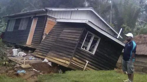 A man views a house that collapsed in a strong earthquake, Tuesday, Feb. 27, 2018, in Halagoli, Hela Province, Papua New Guinea. Severe damage after Monday's powerful 7.5 magnitude earthquake in Papua New Guinea is hindering efforts to assess the destruction, although officials fear dozens of people may have been injured or killed. (Jerol Wepii via AP)