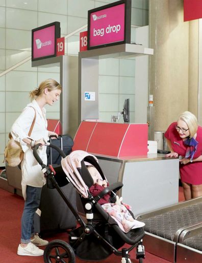 Mum and baby in pram at the Virgin Australia bag drop counter