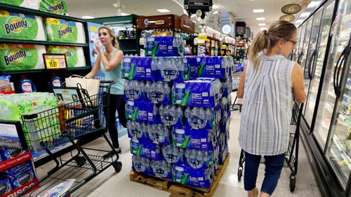 Residents stock up on essential food and water supplies.