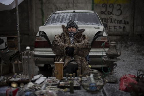 A vendor sits at a flea market in Kyiv, Ukraine, Saturday, February 4, 2023.