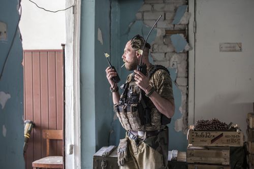 Un soldat ucrainean ține radiouri în timpul luptei grele pe linia frontului în Severodonețk, regiunea Lugansk, Ucraina, miercuri, 8 iunie 2022