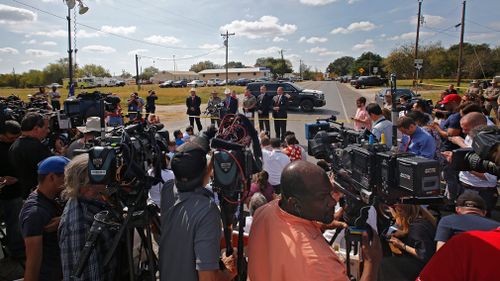 Authorities hold a press conference down from the church while investigators work at the scene of a mass shooting at the First Baptist Church in Sutherland Springs, Texas, USA. (AAP)