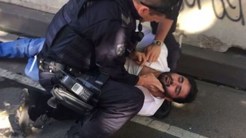 Noori pictured during his arrest by police at Flinders Street.