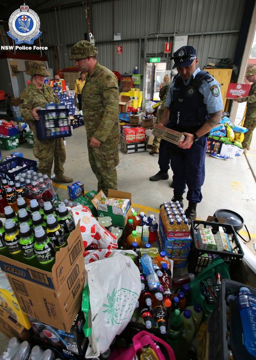 Officers from South Coast Police District and the Australian Defence Force load supplies into trucks. The supplies were delivered to the Milton Showground to support bushfire-affected towns on the state's South Coast.