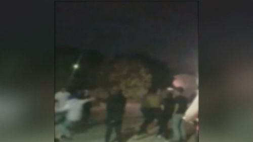 Vision shows a group of teenagers and young adults throwing punches and kicking one another. (9NEWS)