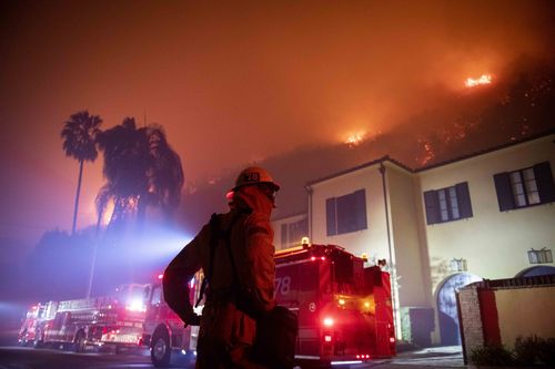 A firefighter watches a flames approach the Mandeville Canyon neighborhood during the Getty Fire, Monday, Oct. 28, 2019, in Los Angeles, Calif. (AP Photo/ Christian Monterrosa)