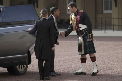 Rishi Sunak is greeted by King Charles III's equerry, Lieutenant Colonel Johnny Thompson, as he arrives at Buckingham Palace for an audience with King Charles III where he will be invited to become Prime Minister and form a new government, in London, Tuesday Oct. 25, 2022. 